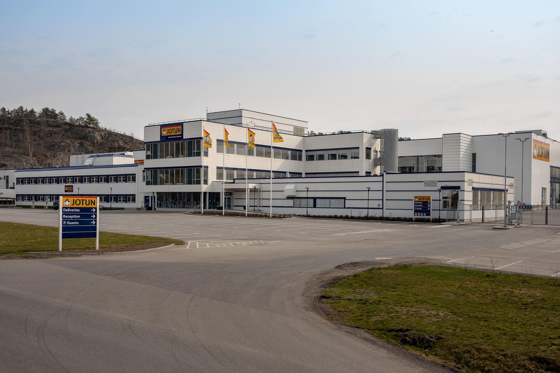 Low white factory buildings with flags in front