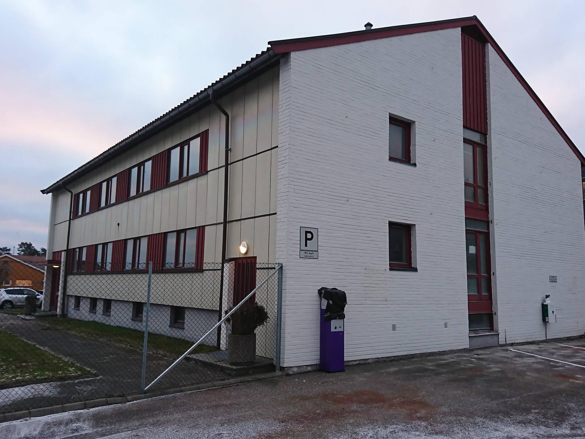 A long white building with red window frames at Fredriksvern